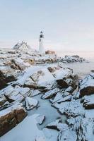 verschneite Felslandschaft und Leuchtturm foto