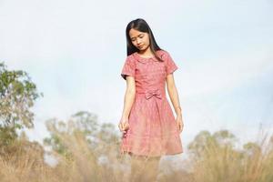 asiatische frau, die glücklich lächelt, hebt ihre hand zum himmel naturhintergrund foto