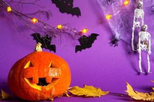 Halloween-Hintergründe von Jack-Laternen-Kürbis, Spinnennetz, Skelett an einem Seil, Spinnen und schwarzen Fledermäusen auf violettem Hintergrund mit schrecklicher Landschaft. horror und ein gruseliger urlaub mit kopierraum foto
