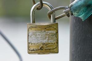 ein Schloss und eine Kette auf einem Metallzaun, der ein Tor verbindet. foto