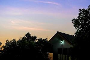 Silhouette von Haus und Baum am Morgen foto