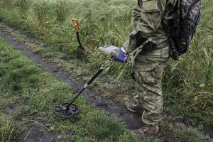 Soldat mit einem Metalldetektor in Feldern foto