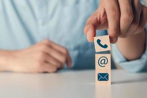 hand setzen holzblöcke würfel symbol telefon, e-mail, adresse. kontakt- oder e-mail-marketing-konzept. foto