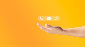 männliche hand, die symbole telefon, e-mail, adresse hält. Kundenservice-Center-Kontakt, Marketing-E-Mail und Newsletter. Ideen für eine Kontaktseite oder E-Mail-Marketing. foto