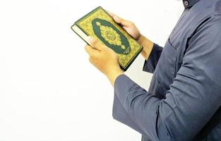 mann, der koran hält und liest. islamischer Hintergrund foto