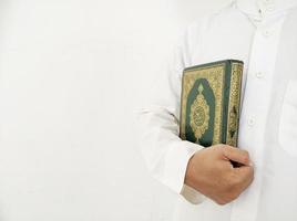 mann, der koran hält und liest. islamischer Hintergrund foto