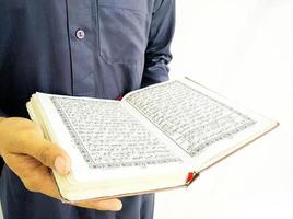 mann, der koran hält und liest. islamischer Hintergrund foto