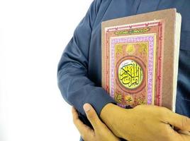 mann, der koran hält und liest. islamischer Hintergrund foto