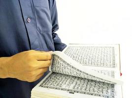 mann, der koran hält und liest. islamischer Hintergrund foto