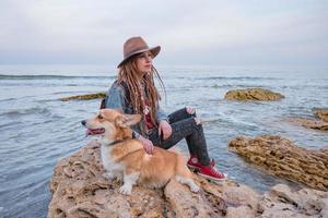 junge Frau mit Corgi-Hund am Strand foto