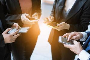 gruppe junger geschäftsleute, die zusammen stehen und smartphone verwenden, konzepte kommunikation. foto