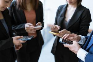 gruppe junger geschäftsleute, die zusammen stehen und smartphone verwenden, konzepte kommunikation. foto