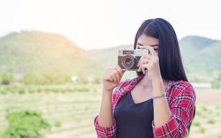 junge Hipster-Fotografin mit einer Vintage-Kamera. foto