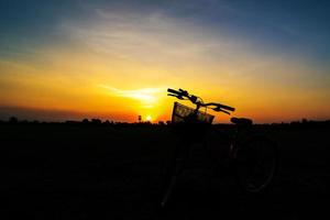 Fahrradschattenbild auf einem Sonnenuntergang foto