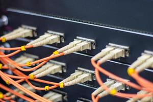 kabelnetzwerk, glasfaserkabel verbinden sich mit dem switch-port im serverraum, konzept netzwerkmanagement foto
