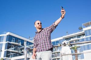 junger bärtiger mann macht selfie am telefon foto