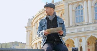 junger männlicher reisender mit karte in der stadt foto