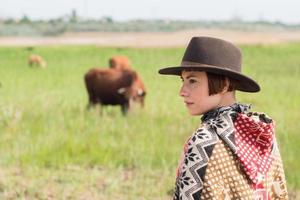 junge Reisende in Poncho und Hut spazieren auf den Feldern und auf dem Bauernhof foto