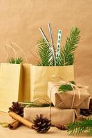 weihnachten und frohes neues jahr null abfall kraftpapier hintergrund. handgemachte geschenkweihnachtsbox, tannenzweige, wiederverwendbares stroh, seitenansicht, kopierraum. umweltfreundliches plastikfreies konzept foto