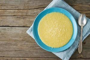 Polenta, Haferbrei mit Parmesankäse auf altem dunklem Holzhintergrund foto