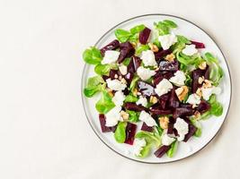 Rote-Bete-Salat mit Feta, Käse, Walnüssen, Feldsalat und Salzlake, eingelegt auf weißem Tisch, Draufsicht, Kopierraum