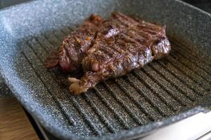 saftiges rindfleischsteak, das in der professionellen küche auf einer grillpfanne gekocht wird. Prime Steak Braten am Grill. leckere, moderne Küche. foto