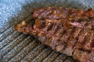 saftiges rindfleischsteak, das in der professionellen küche auf einer grillpfanne gekocht wird. Prime Steak Braten am Grill. leckere, moderne Küche. foto