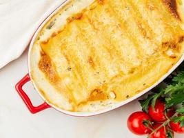 cannelloni mit füllung aus ricotta und petersilie, gebacken mit b-chamelsoße, draufsicht, nahaufnahme foto