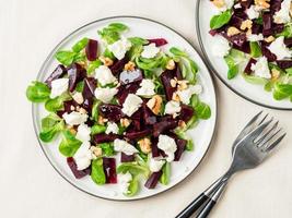 Rote-Bete-Salat mit Feta, Käse, Walnüssen, Feldsalat und Salzlake, eingelegt auf weißem Tisch, Draufsicht