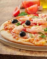 Pizza mit Garnelen, Lachs und Oliven foto