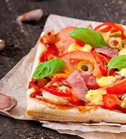 Pizza mit Schinken, Paprika und Oliven
