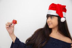 junge frau in der weihnachtsmütze, die weihnachtsgeschenk hält foto