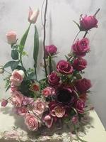 Dunkelrosa violetter Rosenstrauß in Vase Kunstblumenstrauß getrocknete Statice-Blume weiche weiße Tonfarbe im Vintage-Stil, Konzept für Textdesign im vorderen Hintergrund Valentinstag foto