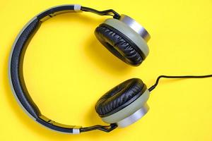 kabelgebundene Kopfhörer in Khaki auf gelbem Hintergrund. foto