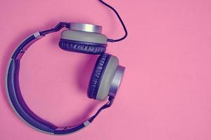 kabelgebundene Kopfhörer in Khaki auf rosafarbenem Hintergrund. Vintage und Retro. foto