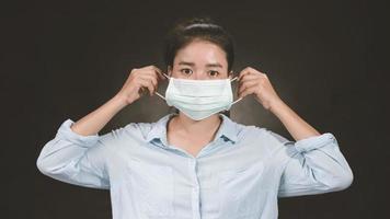 asiatische frau, die gesichtsschutzmaske gegen coronavirus trägt. antivirale medizinische Maske zum Schutz vor Grippeerkrankungen. chirurgische Maske. Coronavirus Krankheit. Covid-19 foto