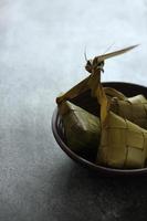 Blick aus der Vogelperspektive auf Ketupat in einer Bambusschale auf dem Tisch foto