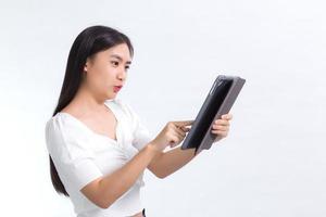 Bild von schönen jungen asiatischen College-Studenten benutzen gerne ein Tablet-Telefon auf weißem Hintergrund. foto