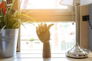 Holzhand zeigt Daumenfinger im Wohnzimmer foto