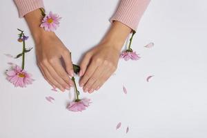 Modekunst Hautpflege von Händen und rosa Blumen in den Händen von Frauen foto