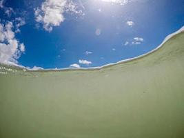 Unterwasser-Meeresspiegelfoto der tropischen exotischen Paradiesbucht mit schönem blauem Himmel und Wolken. foto