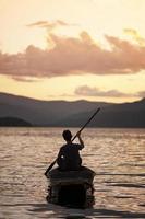 Mann paddelt ein traditionelles Kanu foto