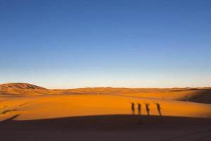 Schatten glücklicher Menschen auf Dünen, Wüste Sahara Marokko, Afrika foto