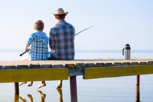 Junge und sein Vater fischen zusammen foto