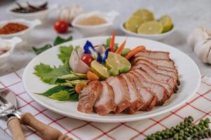 Schweinefleisch mit Zitrone, Zwiebel, roter Zwiebel, Tomate, langer Bohne, Schmetterlingserbsenblüte und Minze. foto