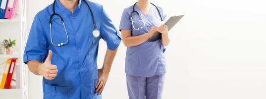 Krankenschwester und Ärztin mit Stethoskop in der Arztpraxis zeigen wie Zeichenkopierraum. Krankenversicherung. foto