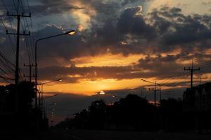 Bewölkter Sonnenaufgang über einer dunklen Straße. foto