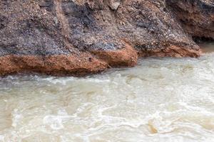 Wasser fließt in Kies, Felsen, unter der Straße. foto