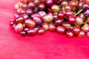 lila Trauben auf einem roten Tuch. foto