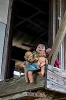 Viele Babypuppen sitzen auf alten Holzhausbalkonen. foto